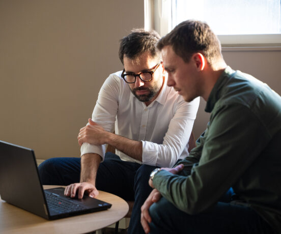 Deux salariés regardant l'écran d'un ordinateur portable